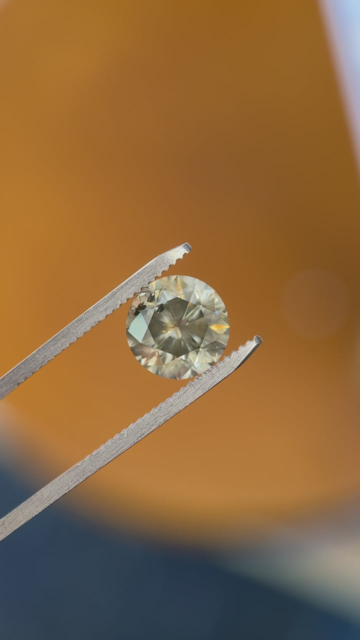 Rotating video of 3.99 carat Fancy Dark Gray diamond in round brilliant cut, showing brilliance, facet pattern, and even tone under natural light, GIA certified from South Africa.