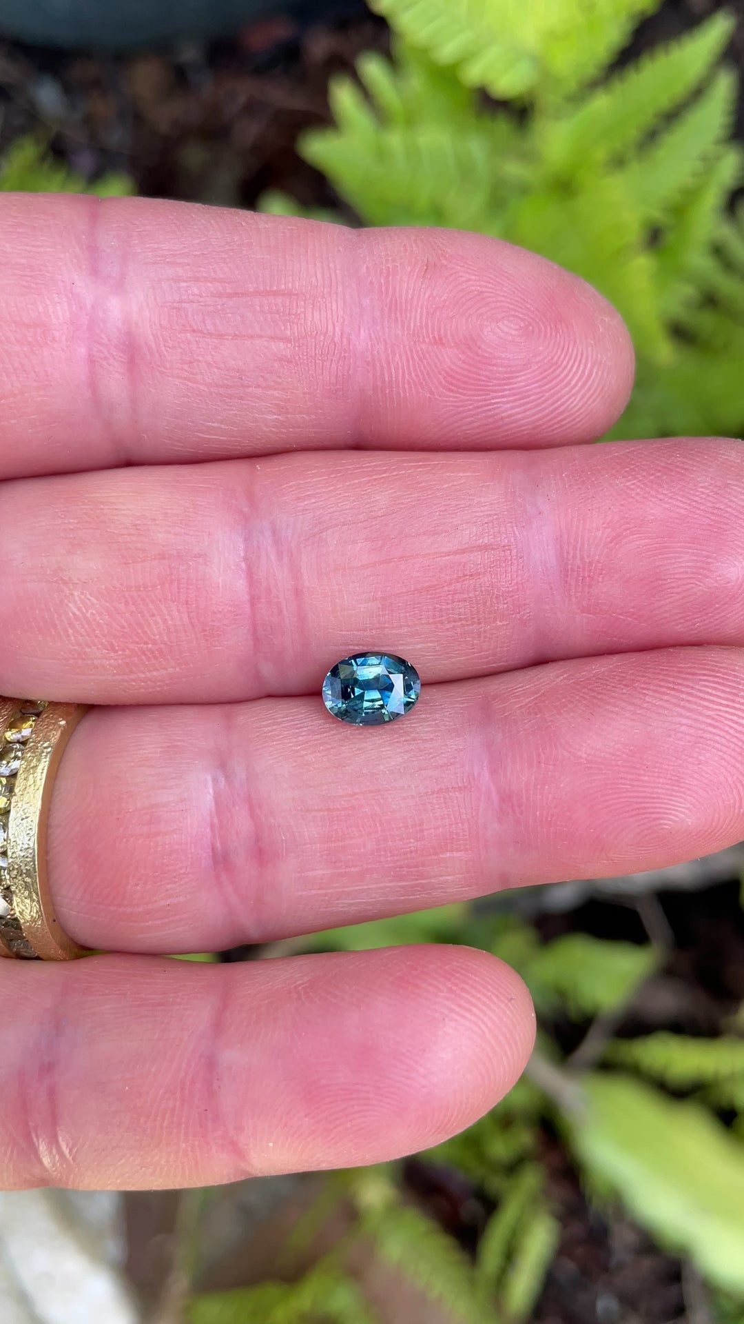 Video of a 1.30-carat sapphire in a mix modified oval brilliant cut, capturing its shifting teal, green, and blue tones under rotating light.