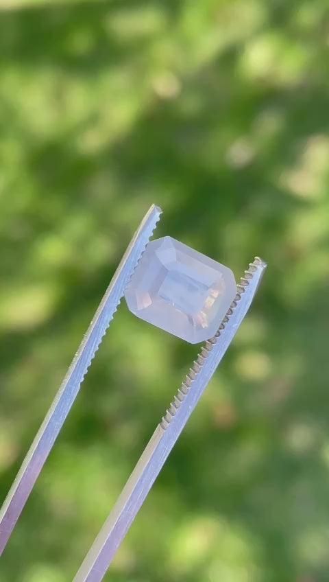 lose-up video of a 5.10-carat opalescent sapphire from Sri Lanka, showcasing its unique octagonal emerald cut and subtle color variations under natural light.