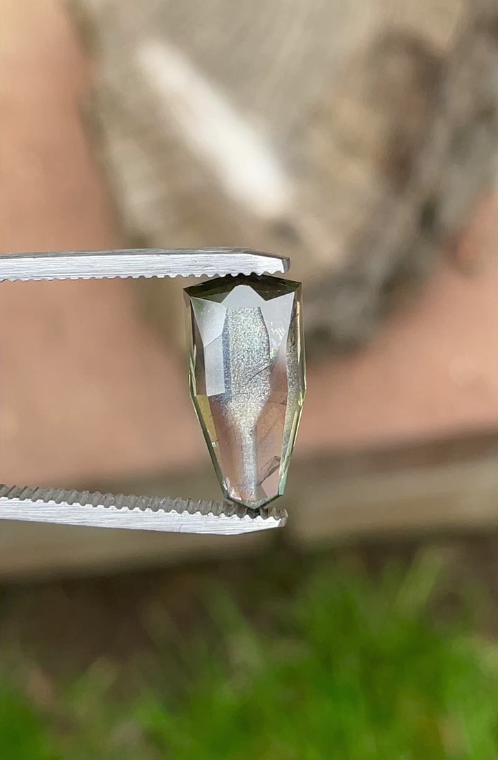 Video of a 6.74ct natural sapphire showing dynamic color change and iridescence in shield step cut.
