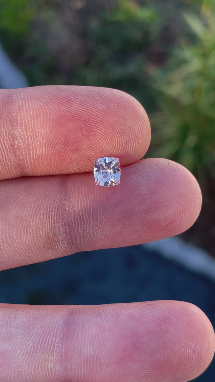 A rotating view of a 1.04-carat pink peach sapphire with a fancy mixed cushion cut, revealing its sparkling facets and natural beauty, ethically sourced from Sri Lanka.