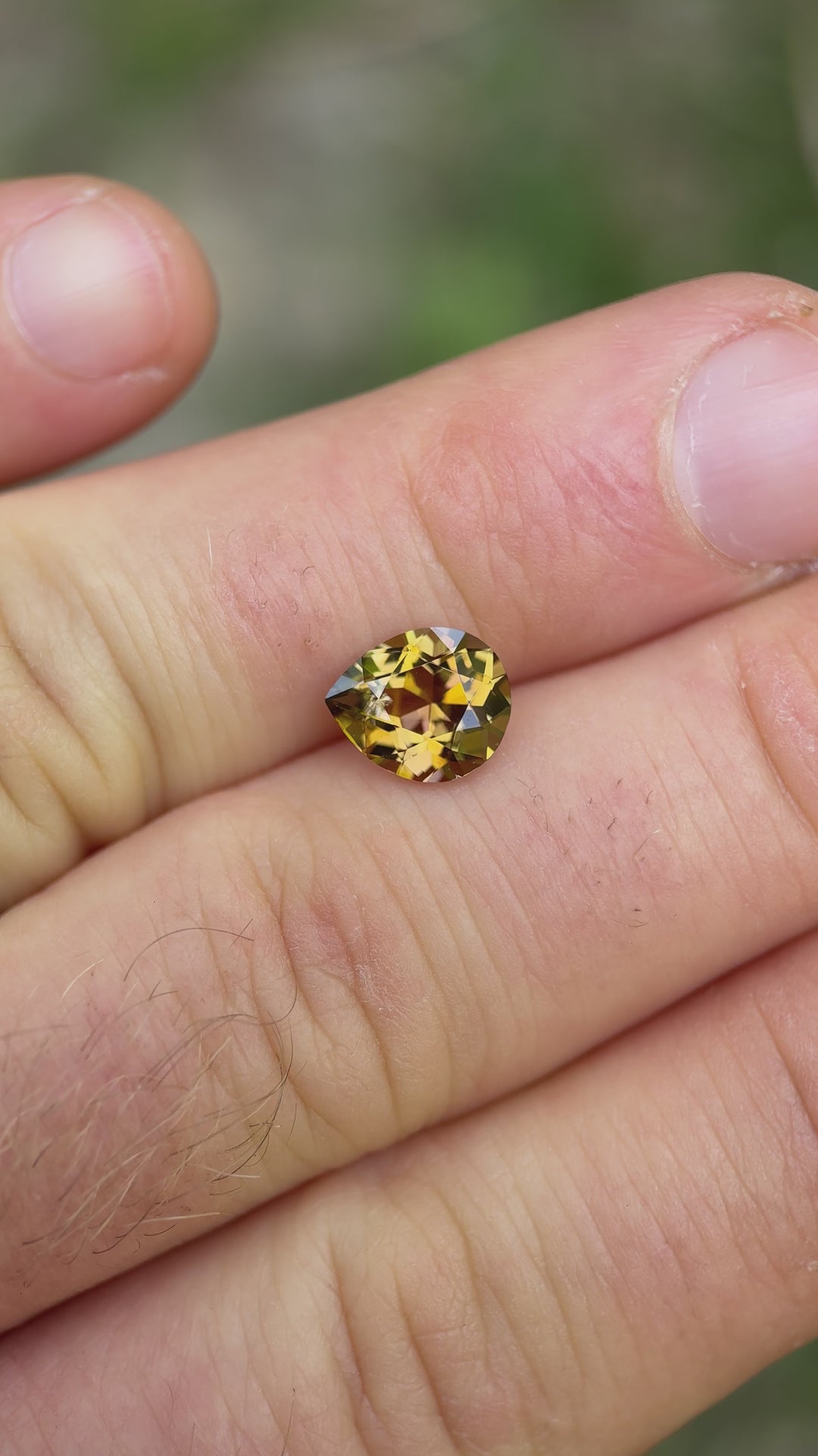 Handheld video of 2.17CT fancy tanzanite in daylight showing off golden and peach hues from multiple angles