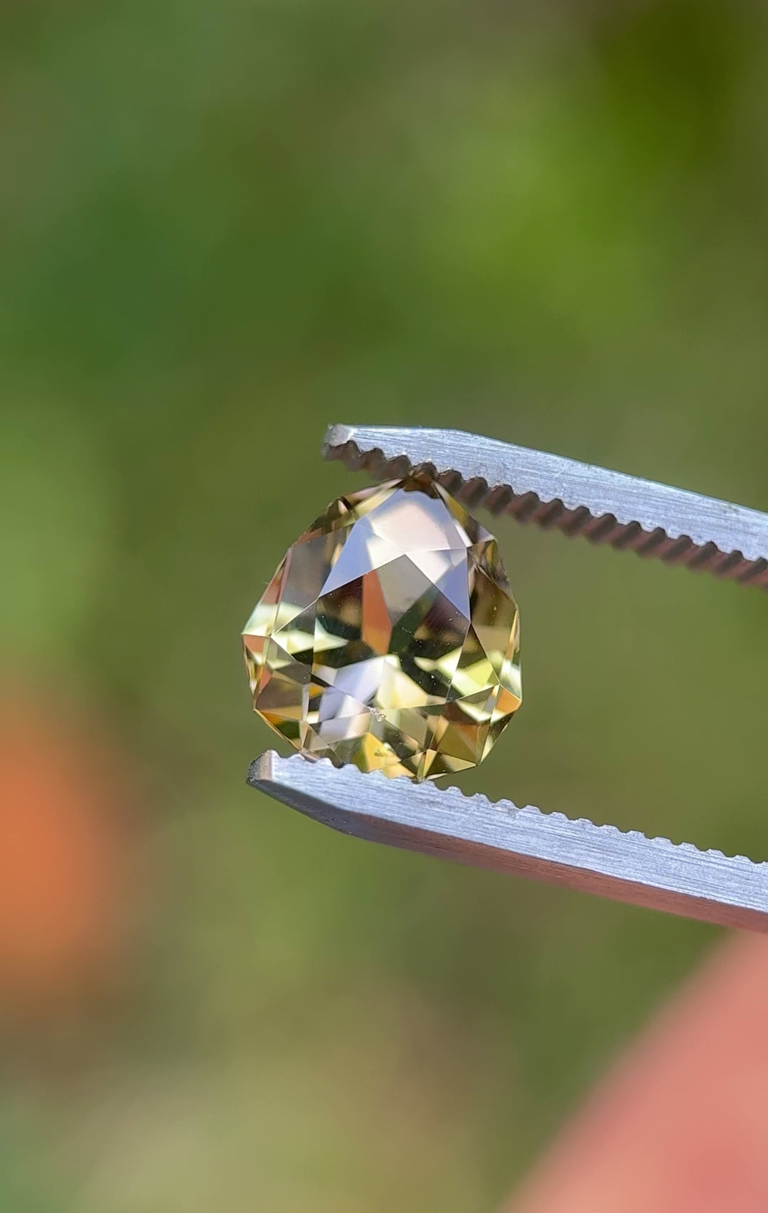 Detailed hand-held video of an untreated 3.25ct Tanzanite from Merelani Hills. The geometric pear cut sparkles with lavender and golden hues under natural light.