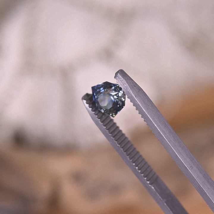 Rotating loose blue and colorless parti sapphire from Sakaraha Madagascar showing the concave shield cut and shifting reflections across the facets.