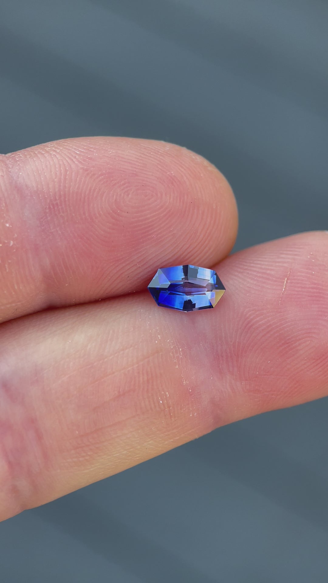 Video showcasing a 1.03 carat bi-color sapphire on a finger, displaying the stone’s custom geometric marquise cut and vivid hues, highlighting its origins from Sri Lanka and its heated treatment.