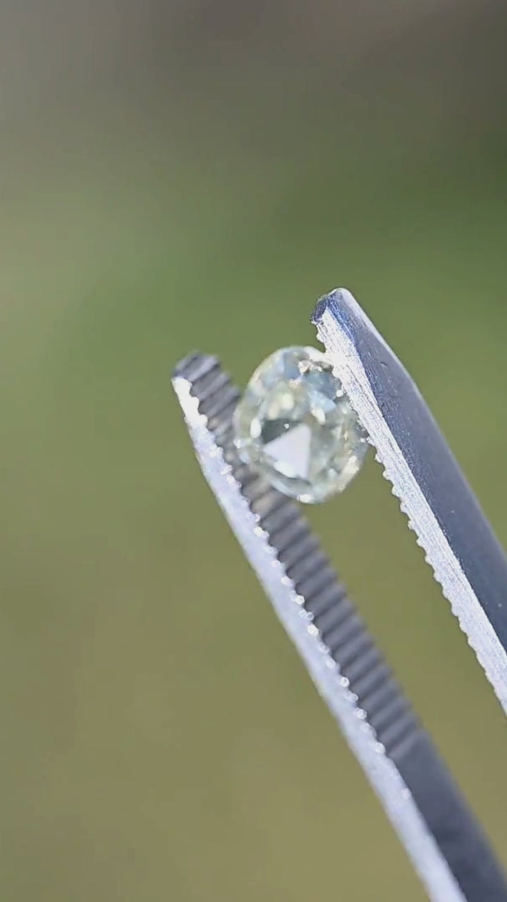 Yellow antique-style cushion diamond slowly turning in tweezers, displaying crisp Old Mine style reflections, strong yellow fluorescence, and warm golden brilliance ideal for a custom engagement ring.
