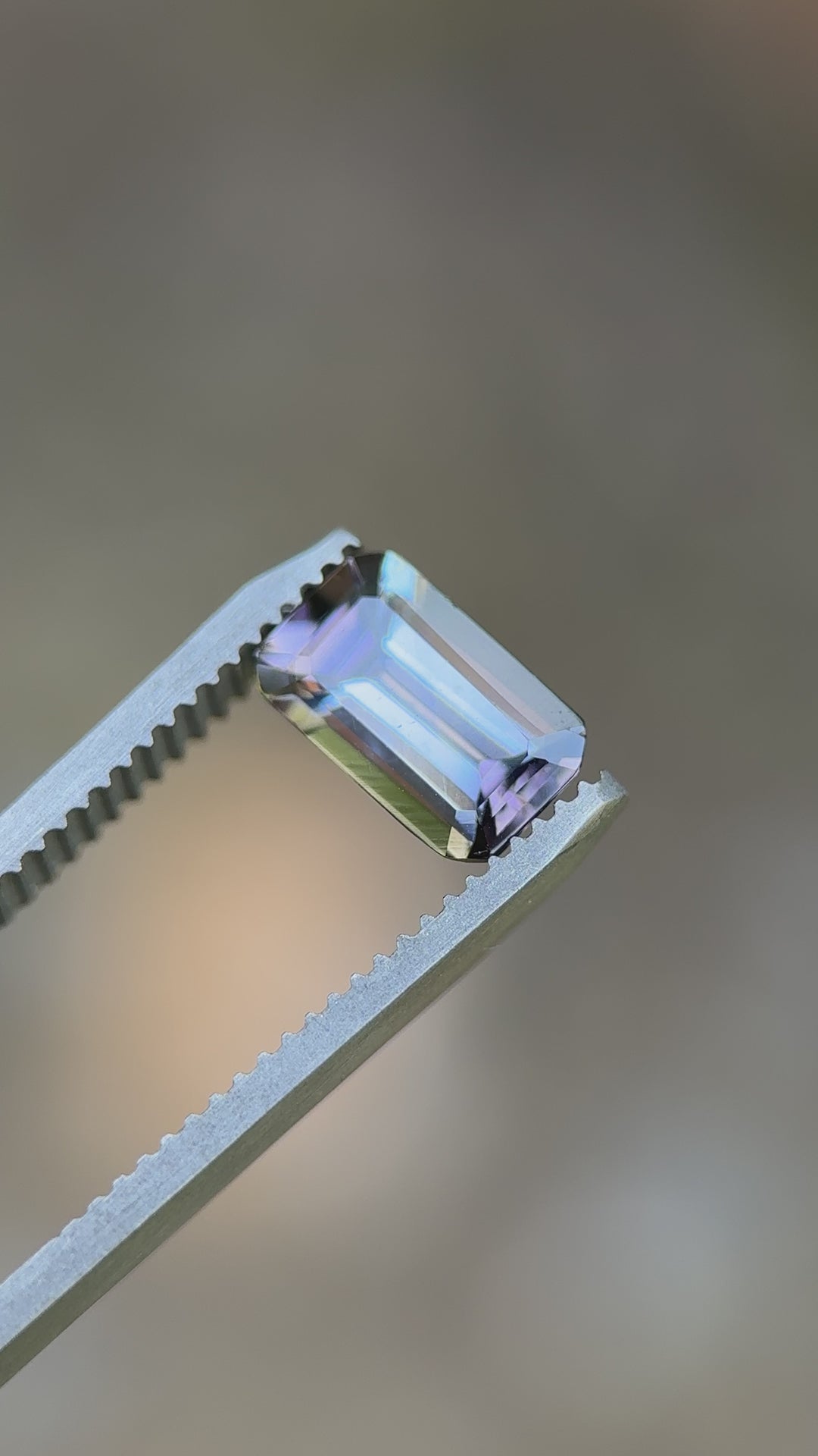 Video showcasing 1.73ct Tanzanite's color play in motion — teal, purple, and pink hues sparkle in emerald cut