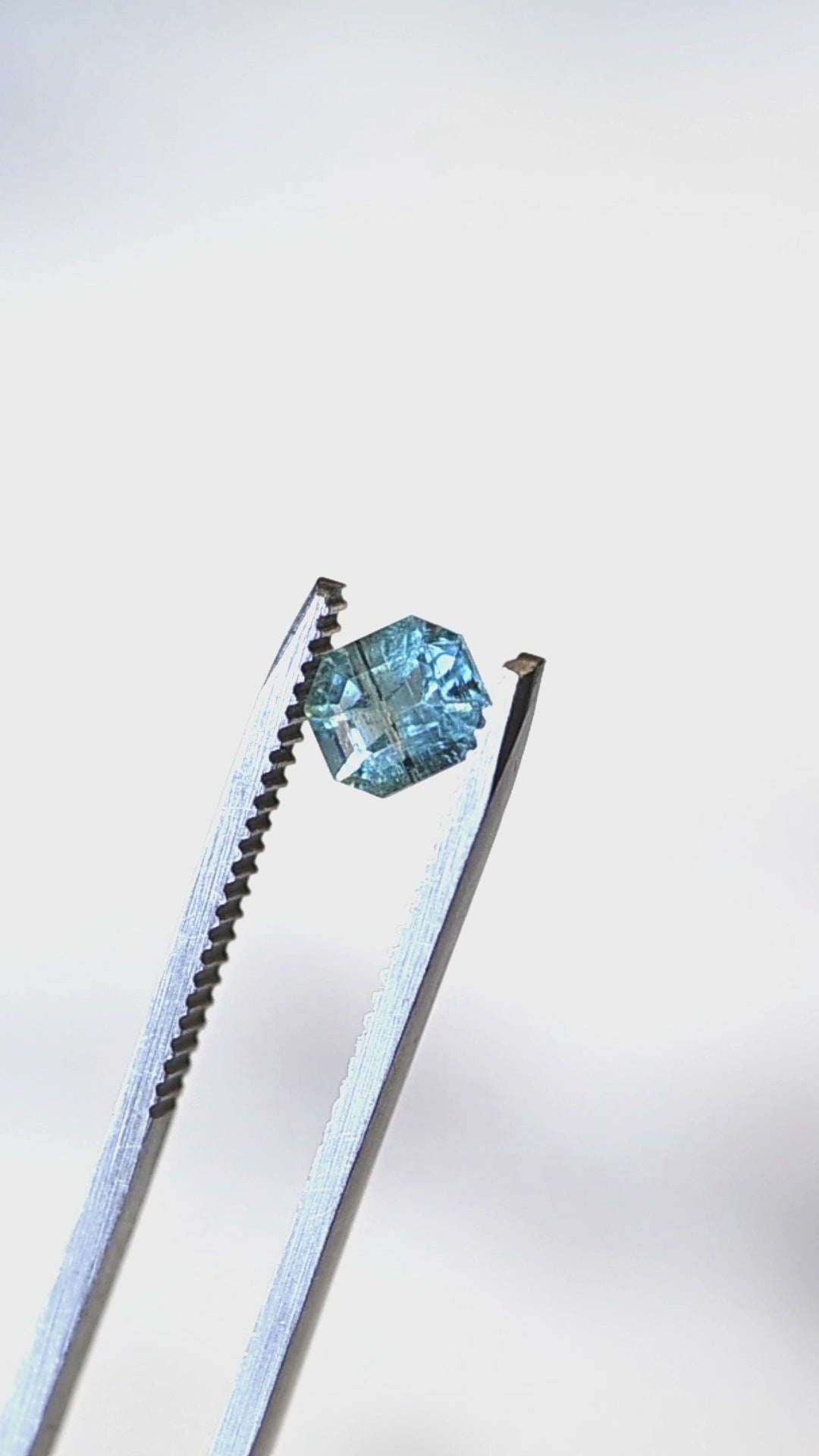 View this untreated 0.88 carat deep teal aquamarine from Nasarawa, Nigeria as it moves through natural light, revealing its precision custom octagonal step cut, vibrant blue-green color, and elegant reflective pattern.