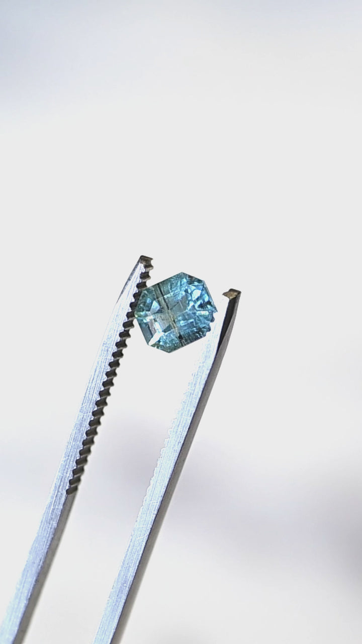 View this untreated 0.88 carat deep teal aquamarine from Nasarawa, Nigeria as it moves through natural light, revealing its precision custom octagonal step cut, vibrant blue-green color, and elegant reflective pattern.