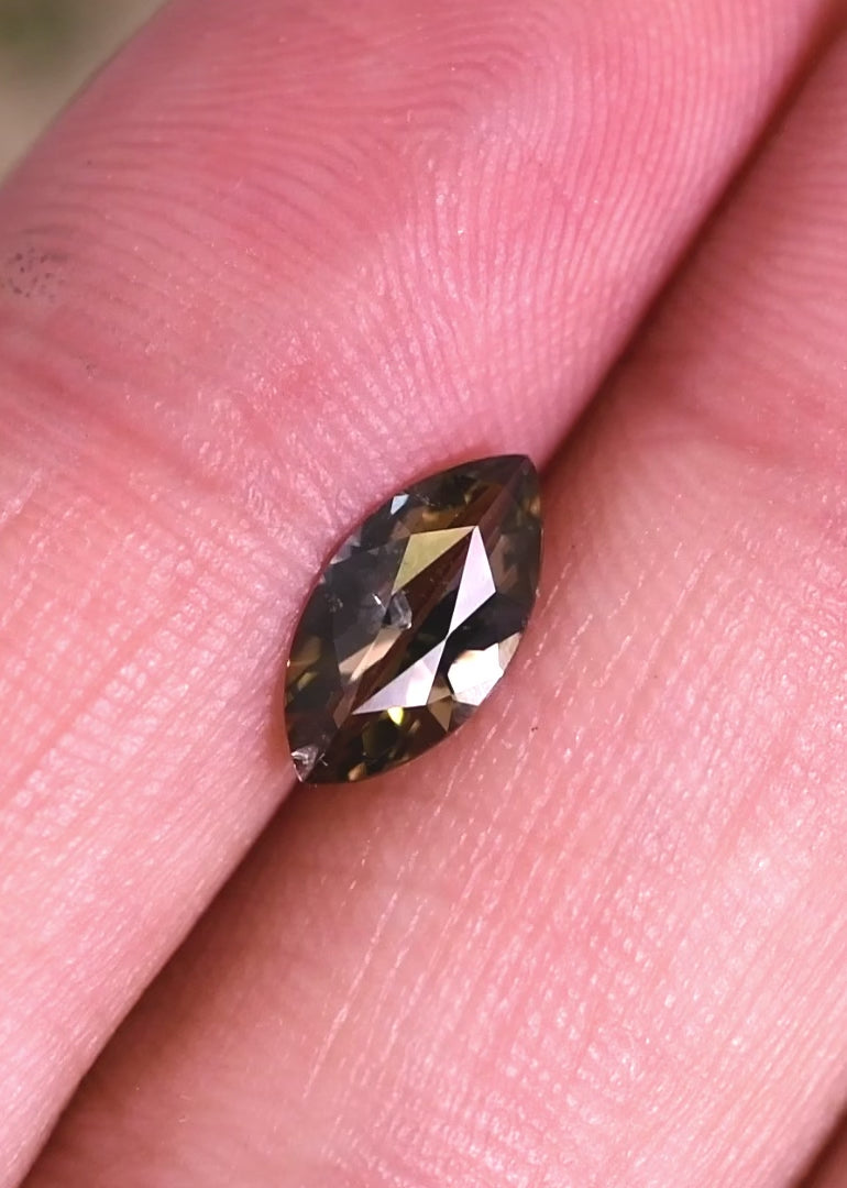 Video of a 1.00 carat untreated yellow-teal-green tanzanite rotating under light, highlighting marquise brilliant cut faceting, natural color play, and sparkle from Merelani Hills, Tanzania