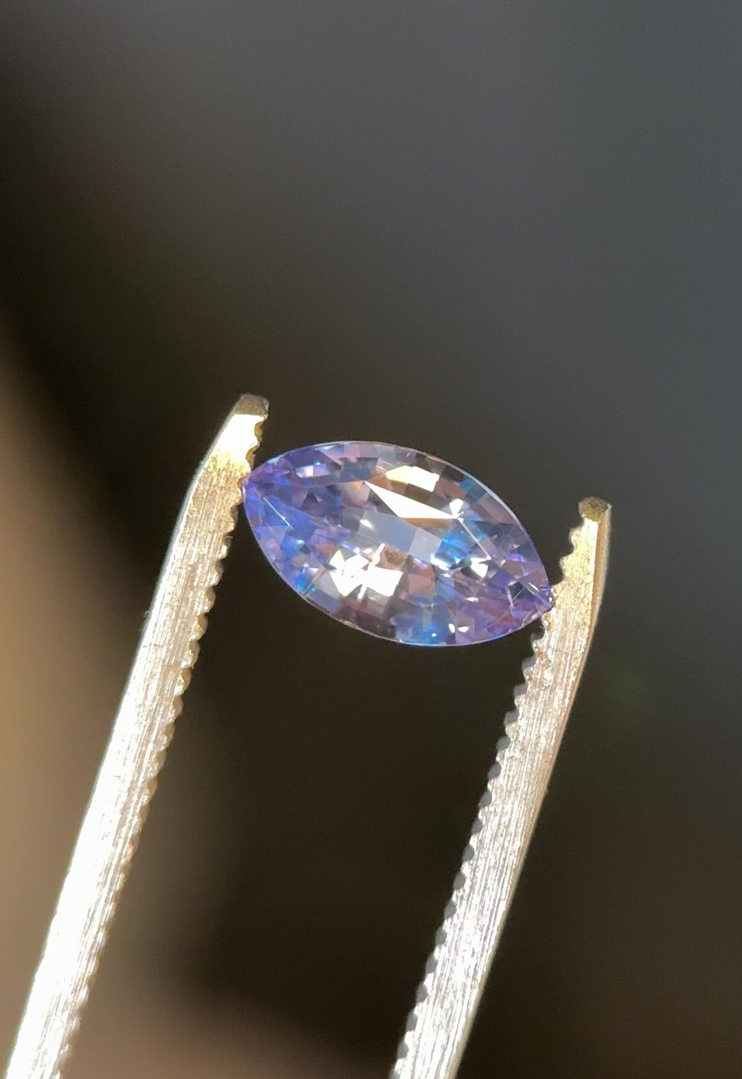 Macro close-up video of 1.70CT marquise mixed cut sapphire from Sakaraha, Madagascar, highlighting vivid cornflower blue tones and subtle violet color shift as gem turns in sunlight.