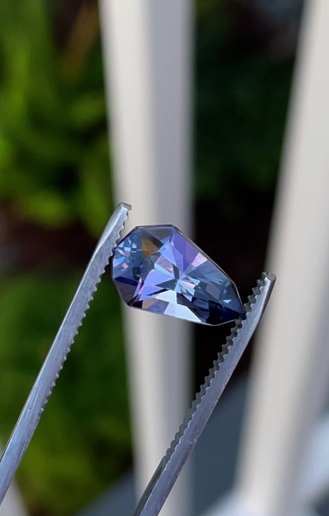 A stunning 3.31-carat tanzanite gemstone with a mix of gray, blue, and purple hues, expertly cut into a modified geometric pear shape, originating from Merelani Hills, Tanzania.