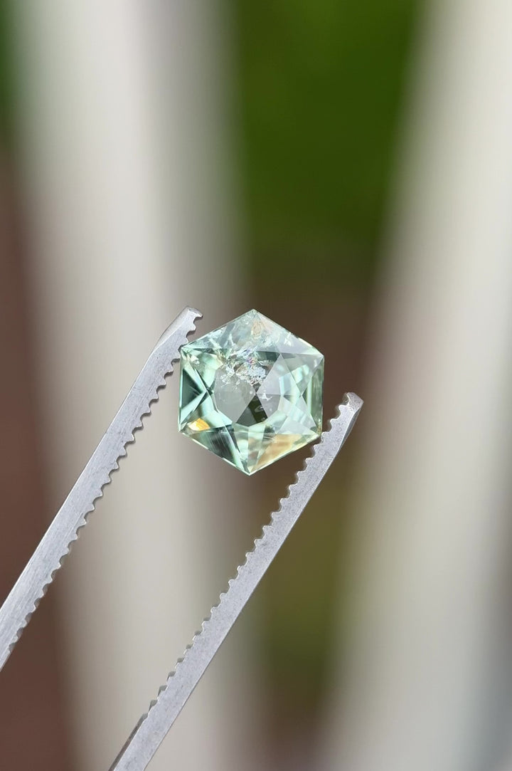 Video of a 1.76 carat untreated Montana sapphire rotating under light, revealing mint sage and teal green color shifts, precision hexagon mixed cut facets, rose cut table, and large open culet