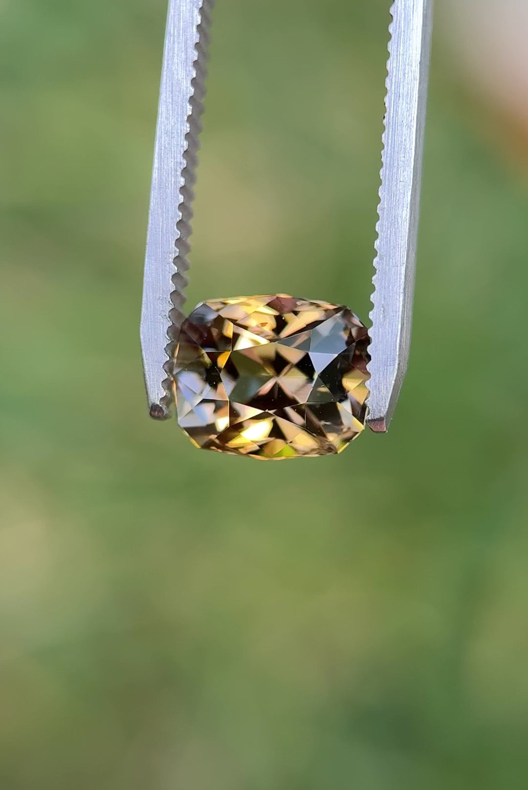 Macro close-up video of 3.81CT fancy Tanzanite turning in tweezers, showing brilliant flashes of lavender, pink, and golden yellow tones, ethically sourced and untreated from the Merelani Hills, Arusha Region, Tanzania.