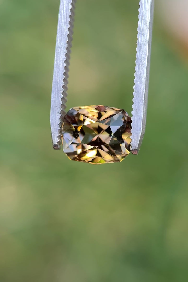 Macro close-up video of 3.81CT fancy Tanzanite turning in tweezers, showing brilliant flashes of lavender, pink, and golden yellow tones, ethically sourced and untreated from the Merelani Hills, Arusha Region, Tanzania.