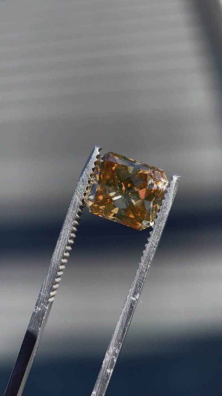 360-degree video of a 3.68-carat radiant cut champagne diamond, capturing its sparkling brilliance and brown-yellow hue in motion.