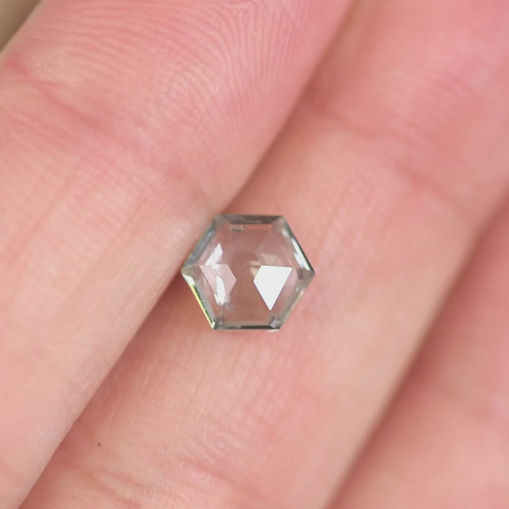 Rotating 1.49ct unheated Montana sapphire in green violet teal tones, hexagon step cut gemstone reflecting light to show natural color shift and step faceting from El Dorado Bar Deposit.