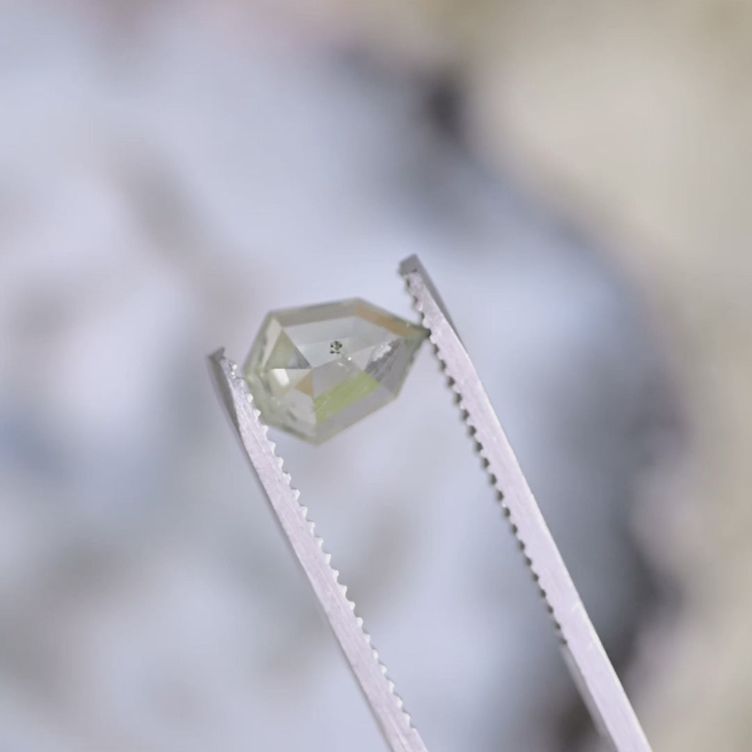 Close-up video of 1.82 carat Montana sapphire, teal seafoam shield rose cut, untreated USA origin gemstone turning under light to reveal color shift and sparkle.