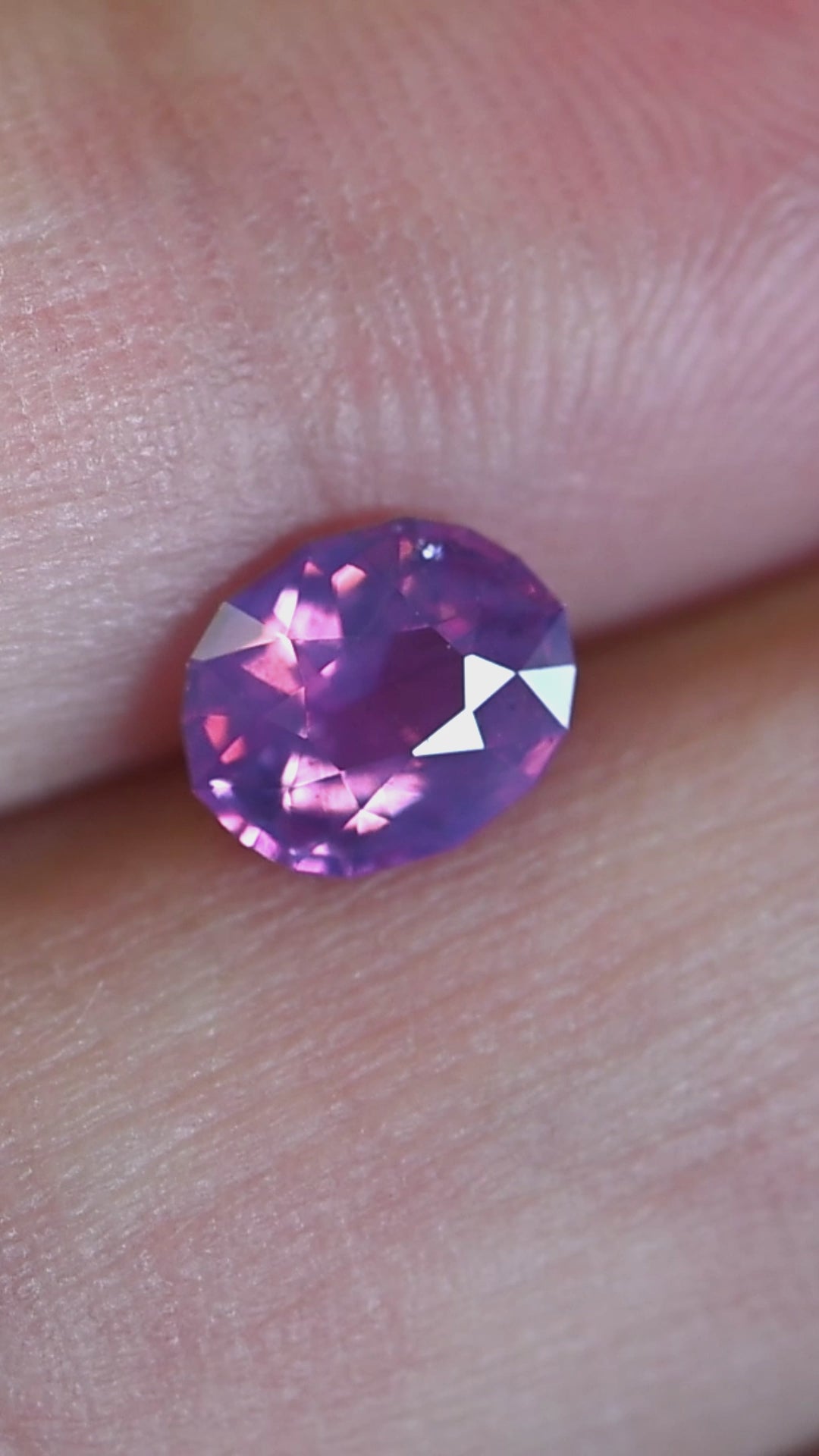 Rotating loose 1.12 carat purple pink sapphire from Ratnapura showing shifting lavender and blush tones across the precision oval mix cut.