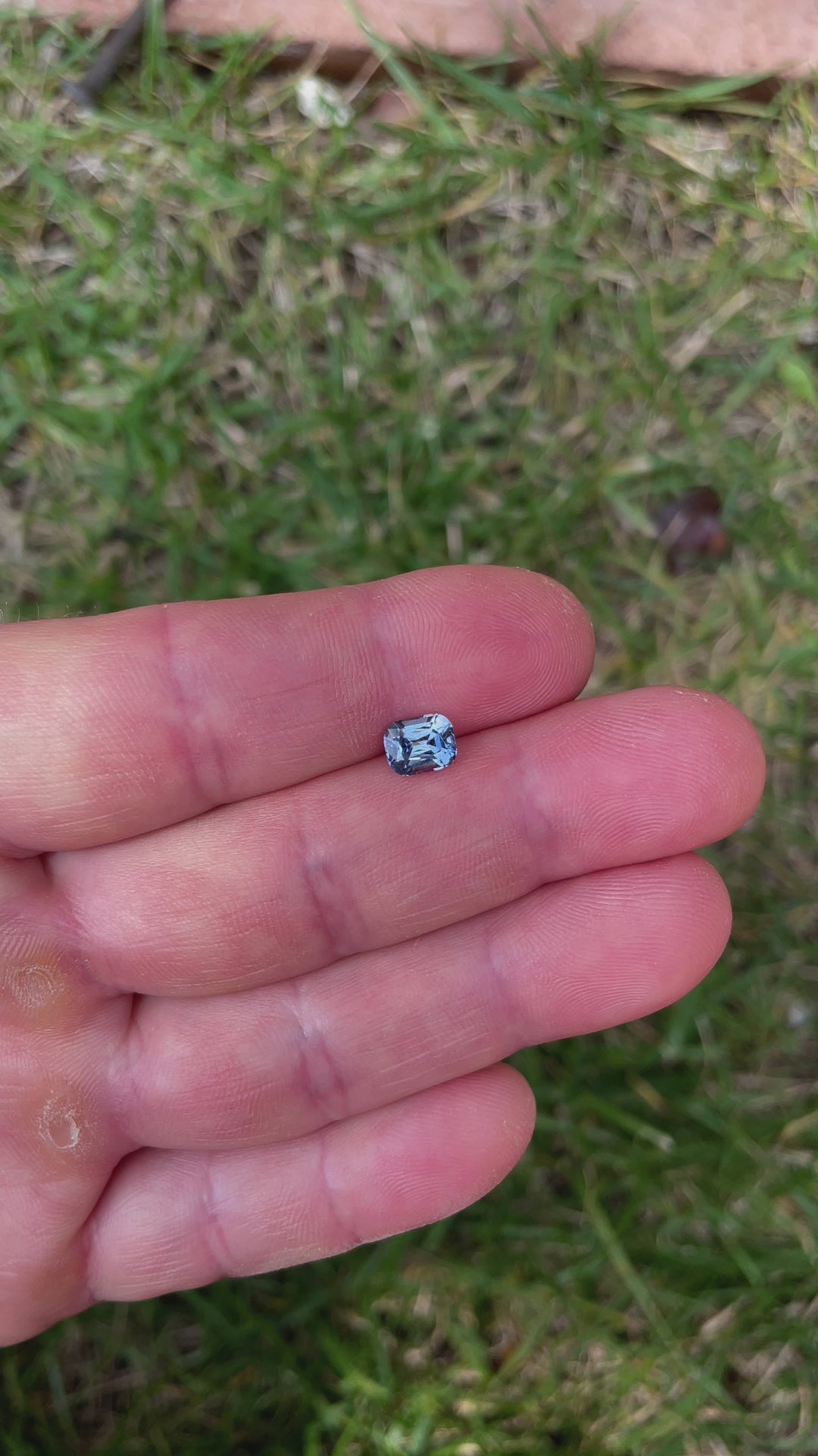 A 1.42-carat color-shifting sapphire displayed under varying light conditions, revealing its transition from teal-indigo to violet. The sapphire is cut in a classic precision cushion shape.