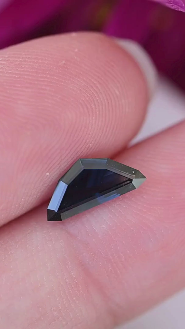 View the scale, elongated silhouette and deep blue color of this untreated 0.99ct step cut kite sapphire from the Central Queensland Gemfields, Australia.
