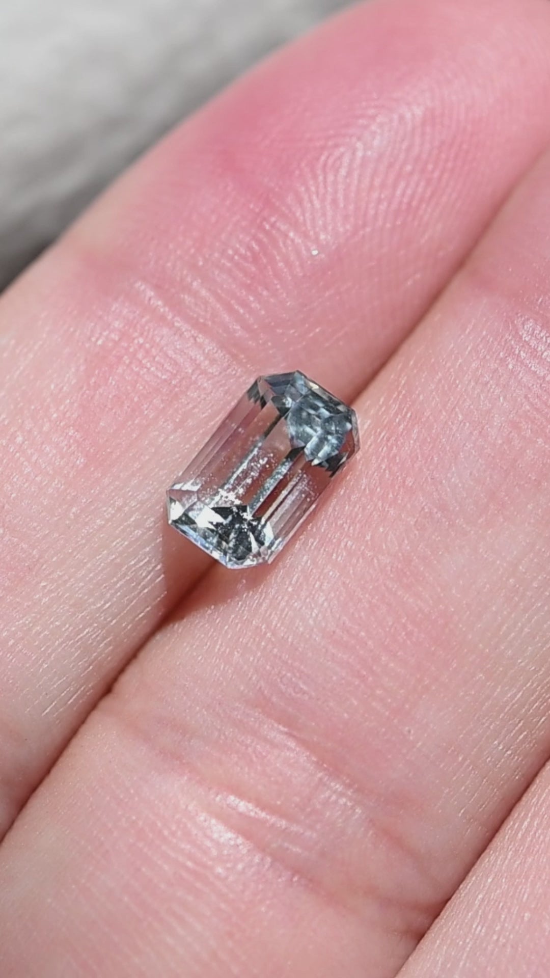 A close-up rotation of this untreated Colorado aquamarine showcasing its custom emerald cut, clean architectural reflections, and beautifully transparent pale blue crystal.