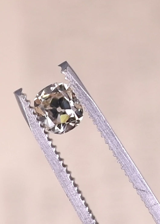 Old mine cut diamond under UV light displaying strong fluorescence and glowing blue effect.