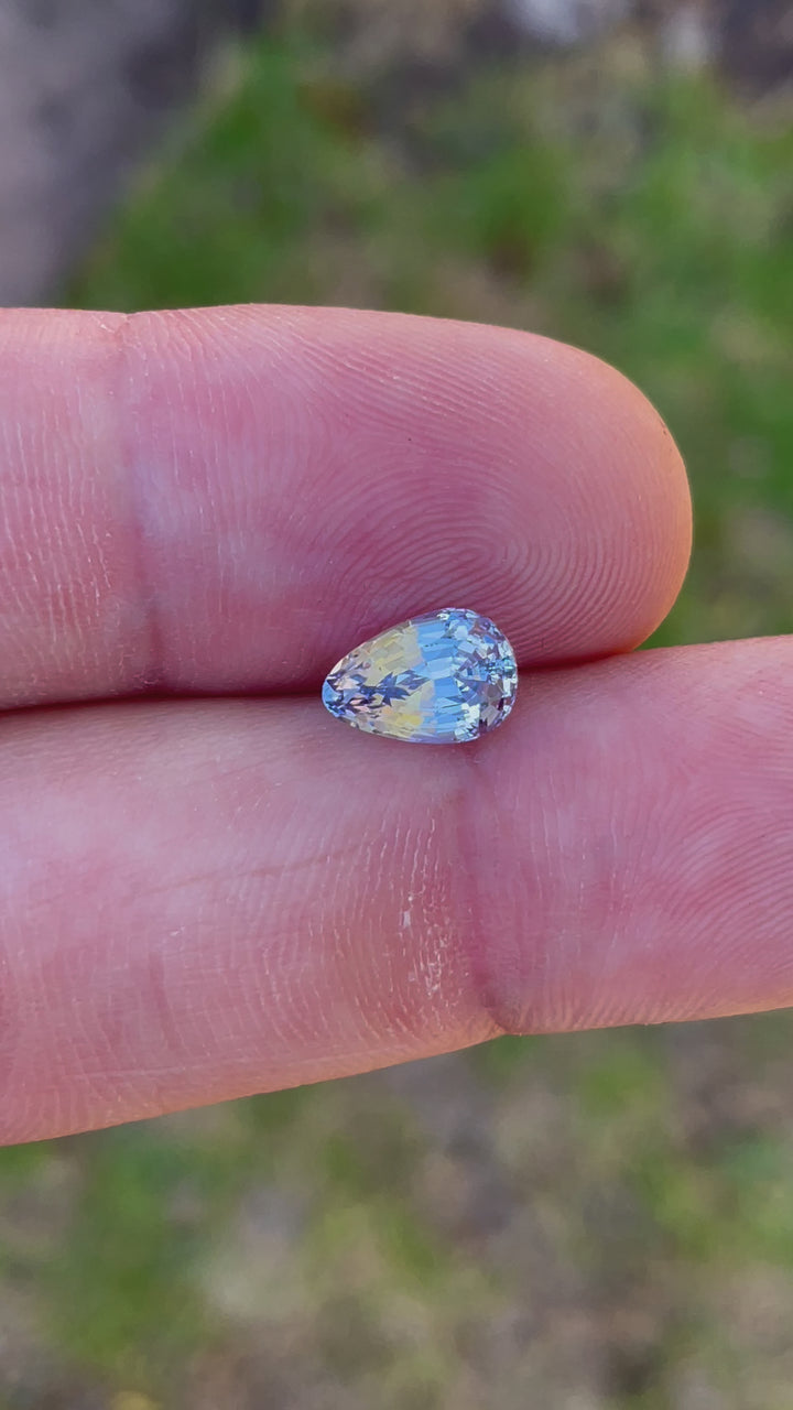 A high-quality video of a 2.39-carat sapphire in cornflower and powder blue tones, cut into a custom brilliant tear drop shape. The gemstone is untreated and sourced ethically from Sri Lanka.