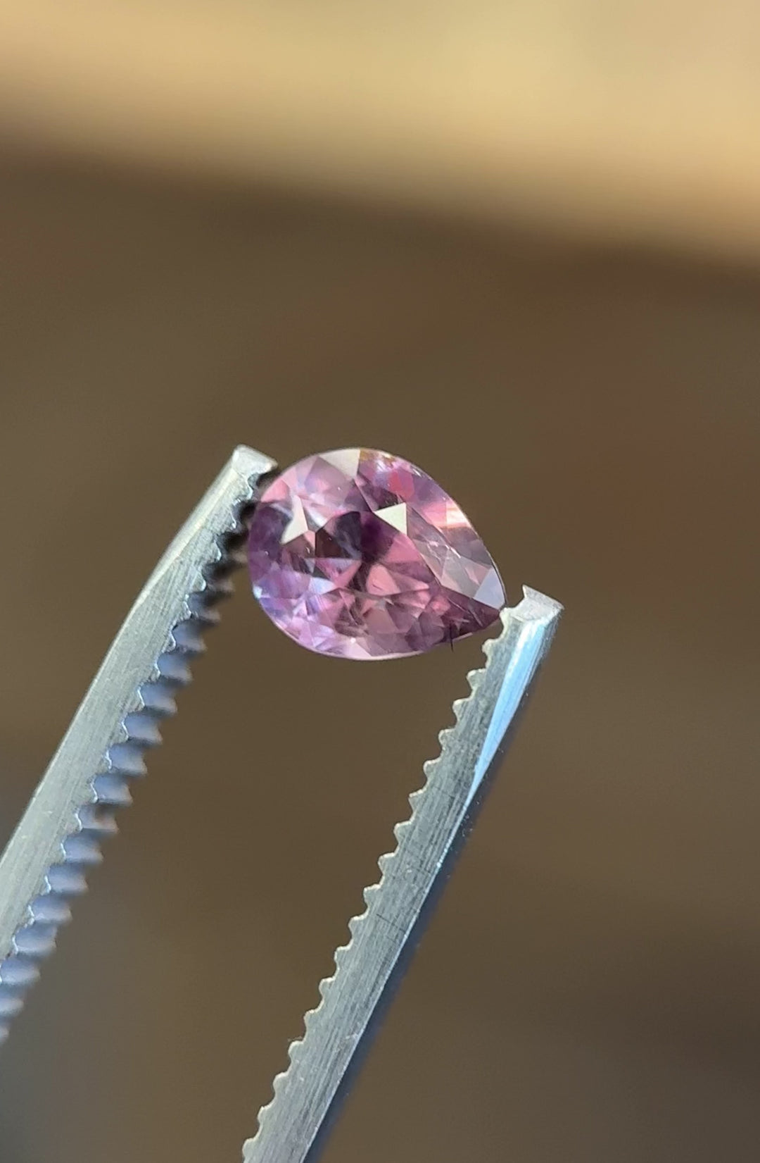 Video of 1.04ct color change sapphire in modified brilliant pear cut, shifting from mauve to red tones