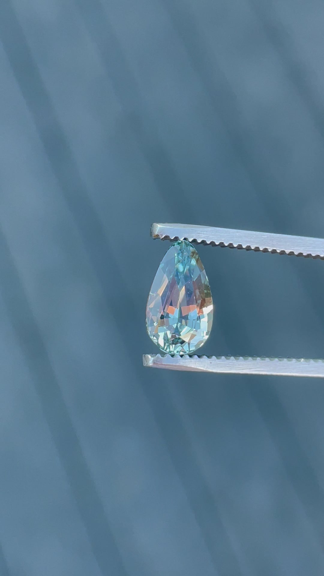 Detailed video showcasing the mesmerizing color shift and transparency of a 2.00-carat custom teardrop sapphire under natural lighting, emphasizing its seafoam and lime green shades, sourced from Sri Lanka and untreated for authenticity.
