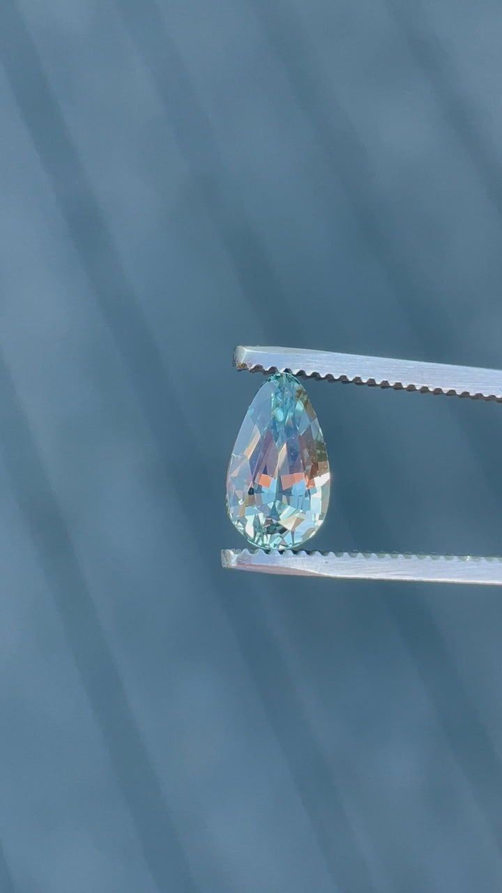 Detailed video showcasing the mesmerizing color shift and transparency of a 2.00-carat custom teardrop sapphire under natural lighting, emphasizing its seafoam and lime green shades, sourced from Sri Lanka and untreated for authenticity.