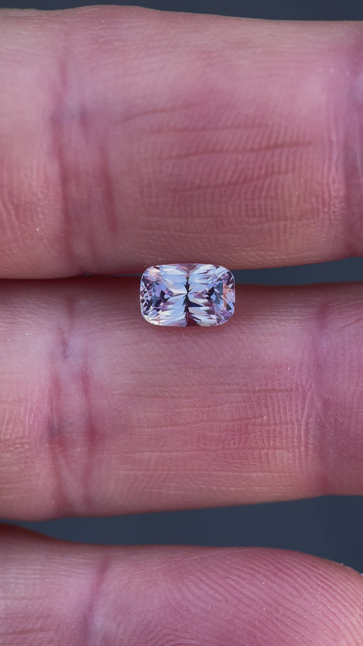 360-degree view of a pastel pink and purple rectangular cushion sapphire, weighing 1.57 carats, displaying its brilliant mixed cut design and sourced from Sri Lanka.