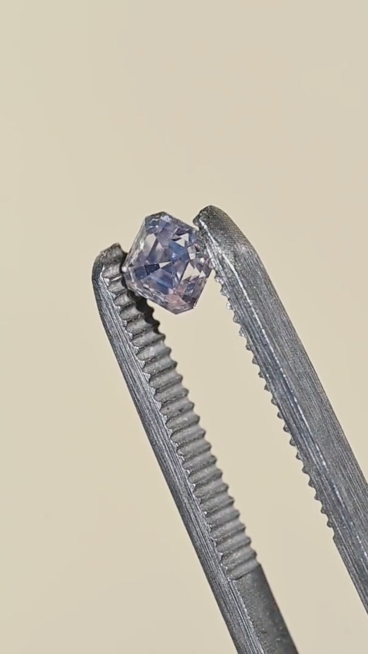 Natural Canadian Asscher cut diamond rotated in tweezers under direct sunlight, revealing bright flashes across its tiered step facets and warm M color.
