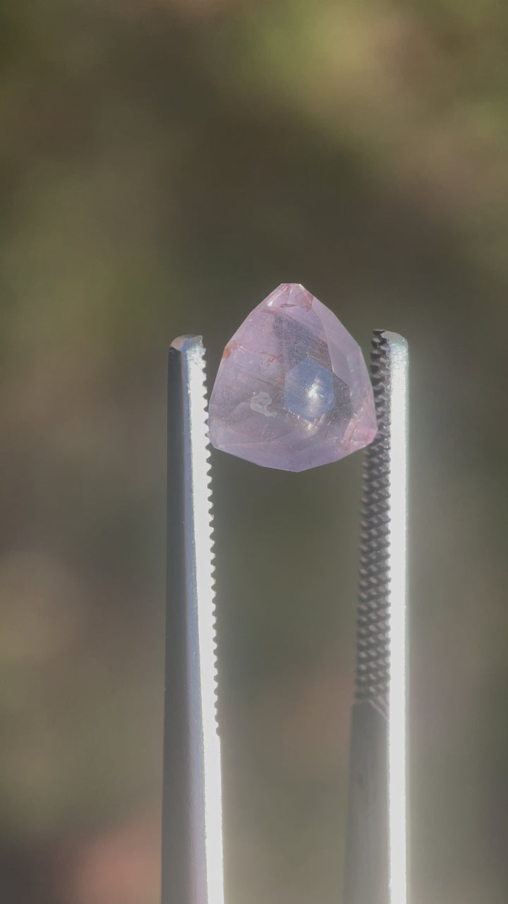 A video showcasing the intricate facets and rare color-changing properties of a 4.19-carat sapphire. The custom geometric trillion cut highlights its unique gray, teal, and yellow hues.