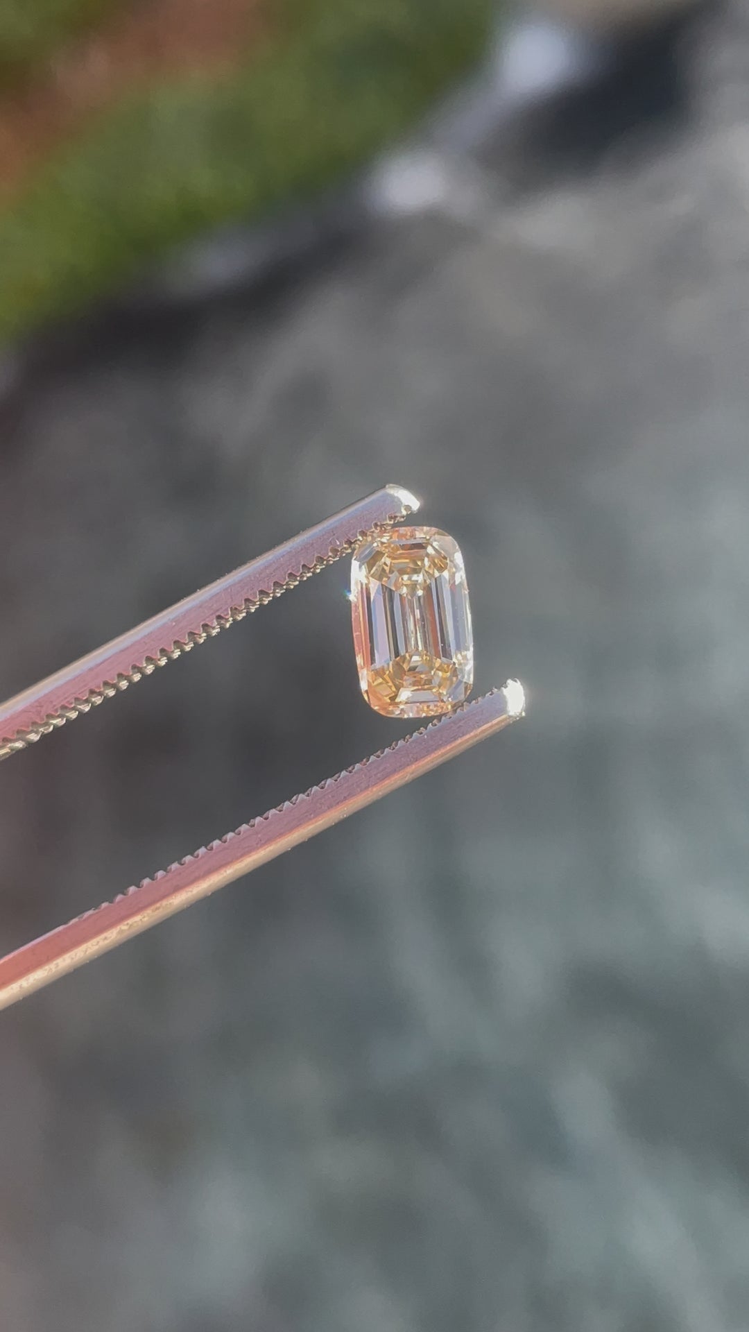 A 1.02-carat antique-style elongated step-cut cushion diamond in light fancy yellowish brown, shown under natural light to highlight its clarity and brilliance.