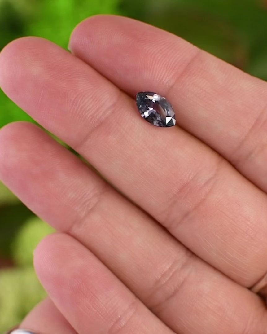 Macro video of 1.68 carat violet gray sapphire resting on fingertips, capturing brilliance, color transition, and clarity of the precision marquise mixed cut, untreated sapphire from Sakaraha, Madagascar.