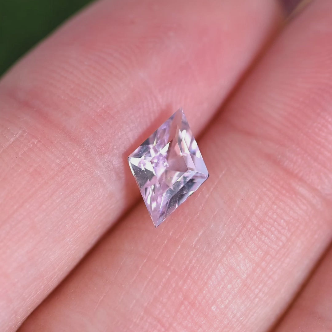 Rotating loose blush pink sapphire kite step cut from Madagascar revealing subtle pink tones and reflective facets under movement.