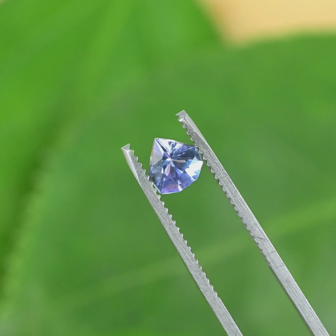 Rotating loose periwinkle violet tanzanite from Merelani Hills Tanzania showing the geometric shield cut and shifting blue violet reflections.