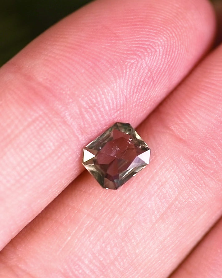 Close-up motion video of 1.31 carat teal, yellow, and green sapphire rotating slowly, revealing facets, brilliance, and natural zoning in its custom modified radiant cut, unheated sapphire from Umba River Valley, Tanga, Tanzania.