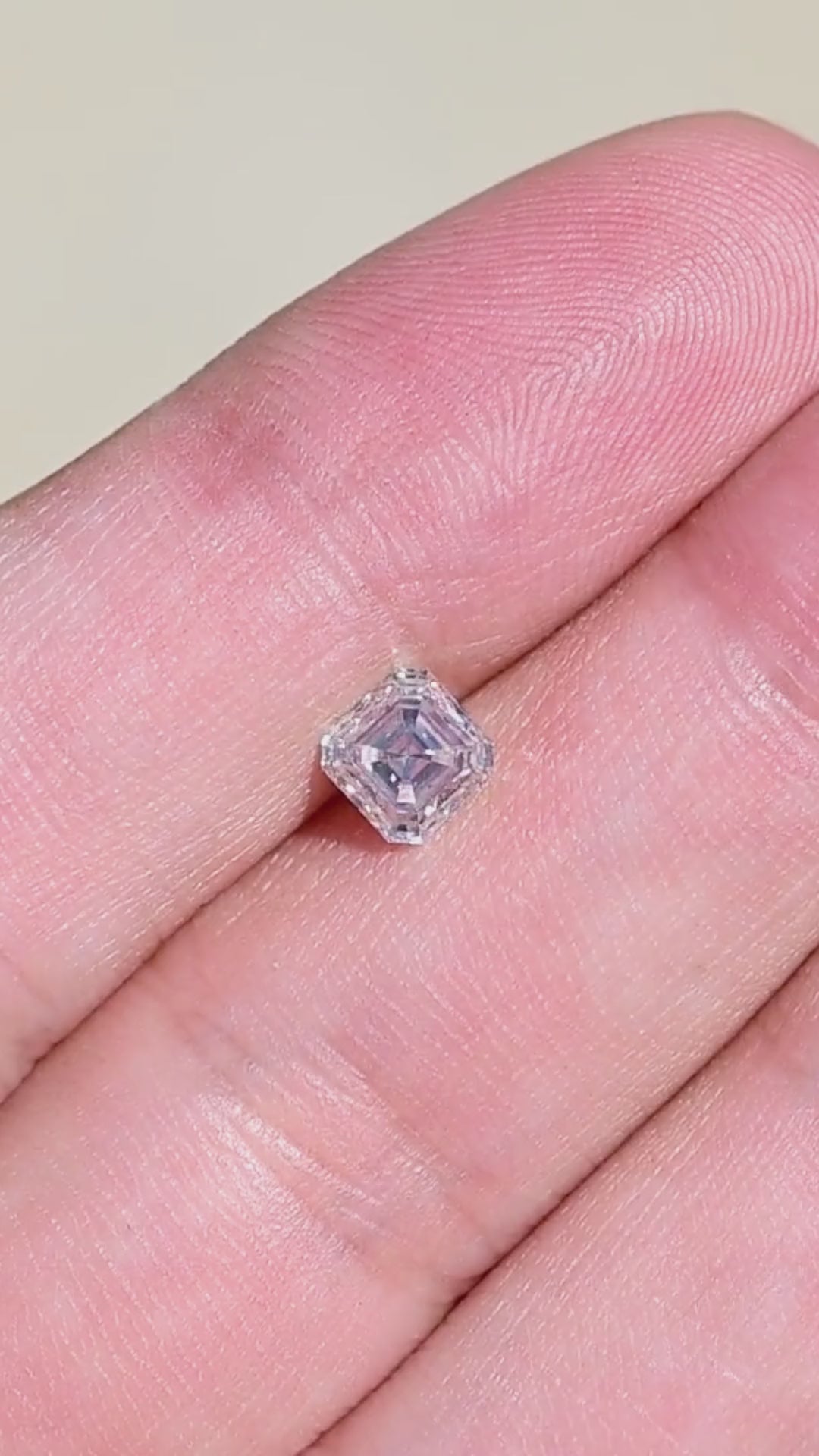 1.01 carat natural Canadian Asscher cut diamond shown on a hand, demonstrating its 5.22 mm face-up size, square proportions and subtle warm coloration.