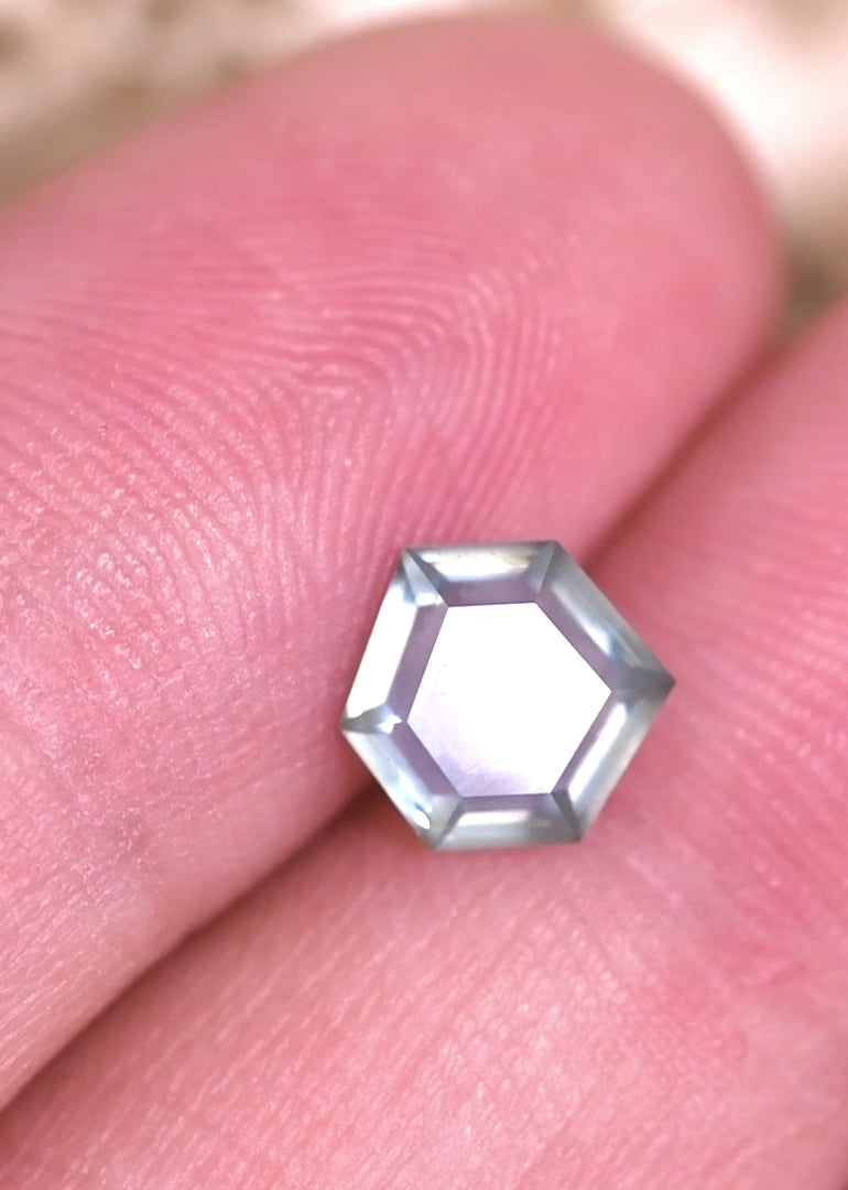 Video of a 1.37 carat teal blue seafoam Montana sapphire rotating in tweezers, revealing geometric hexagonal step cut facets, natural color zoning, and untreated sapphire brilliance under shifting light.