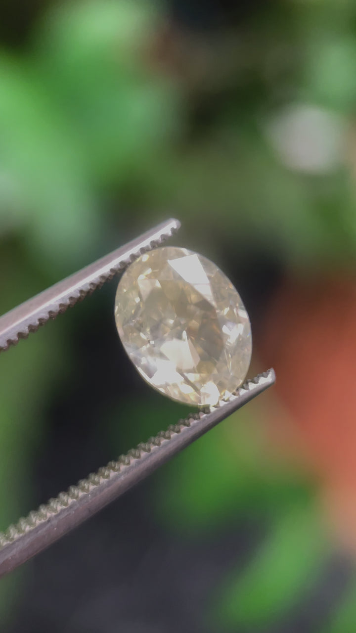 A rotating view of the 2.71-carat oval modified brilliant diamond, highlighting its SI1 clarity and faint yellow opalescence against different lighting angles.