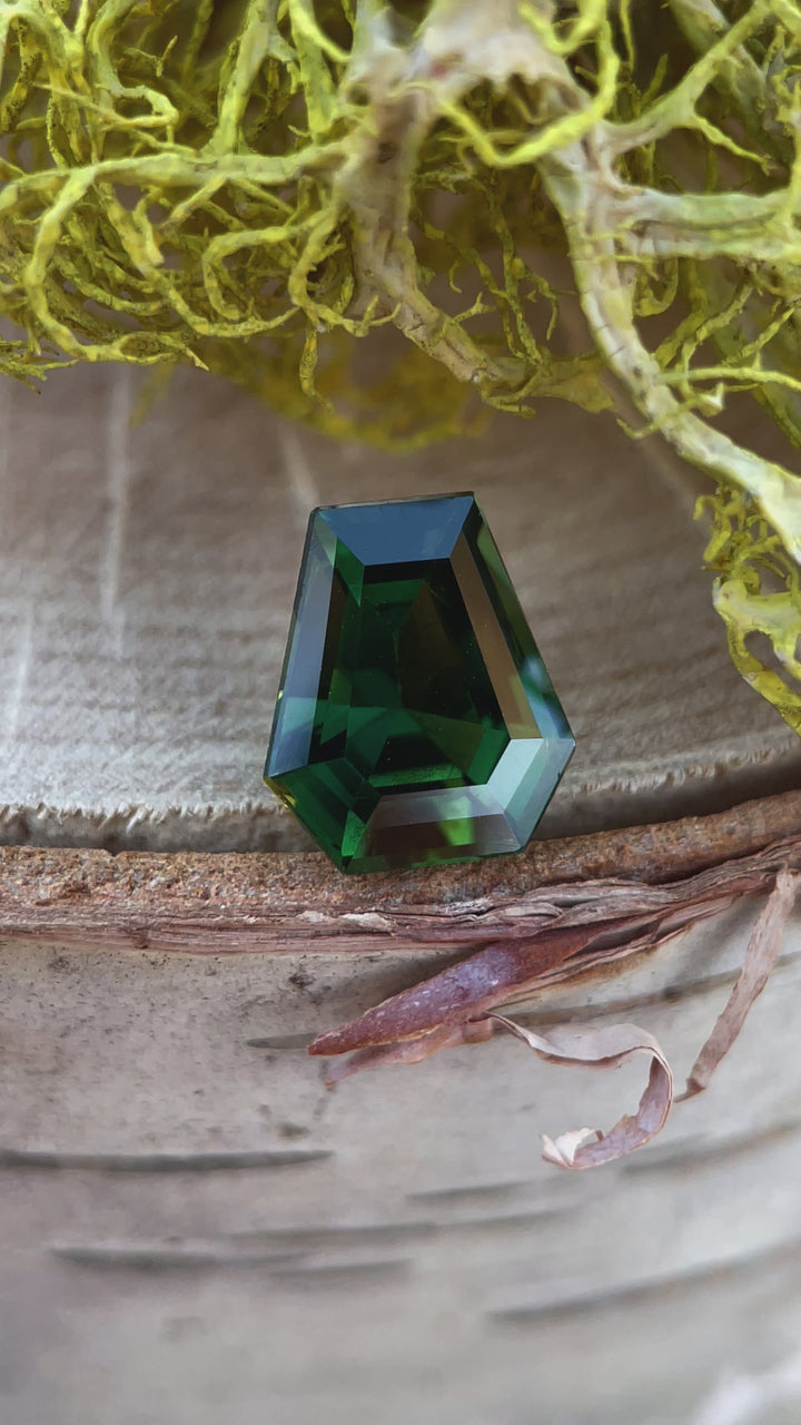 A detailed video showcasing a natural 2.38-carat teal green sapphire in a step-cut coffin shape, with no heat treatment, originating from Madagascar.