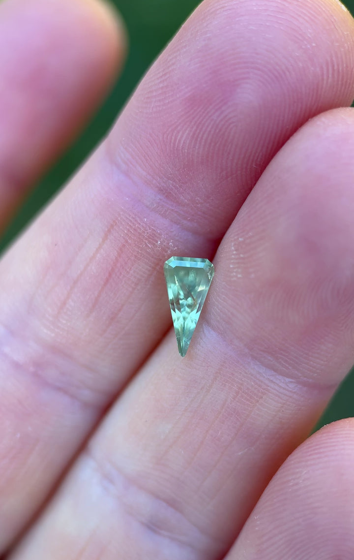 360-degree video of a 1.57 carat unheated kite step cut sapphire from Chimwadzulu Hill, Malawi, displaying its vibrant yellow-green and blue-green tones in natural light.