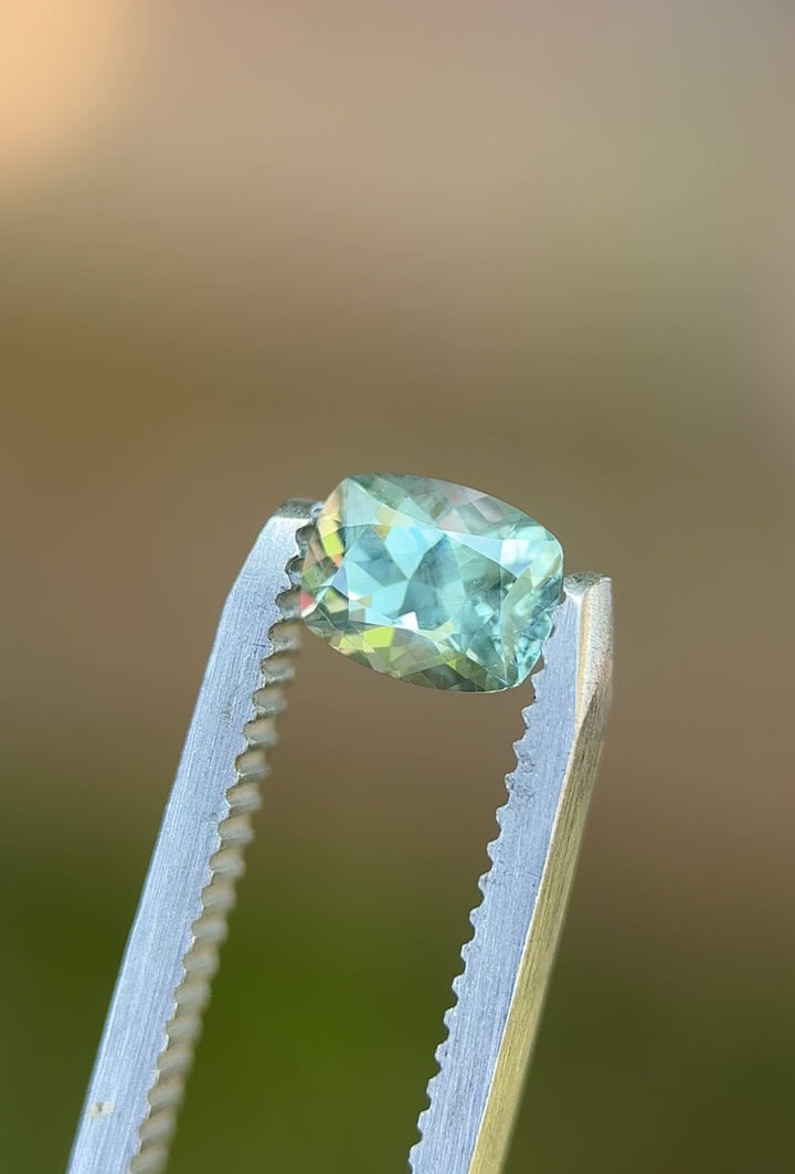 Close-up tweezer video of natural Montana sapphire, 1.15ct, showcasing unheated teal, blue, and green brilliance from El Dorado Bar deposit