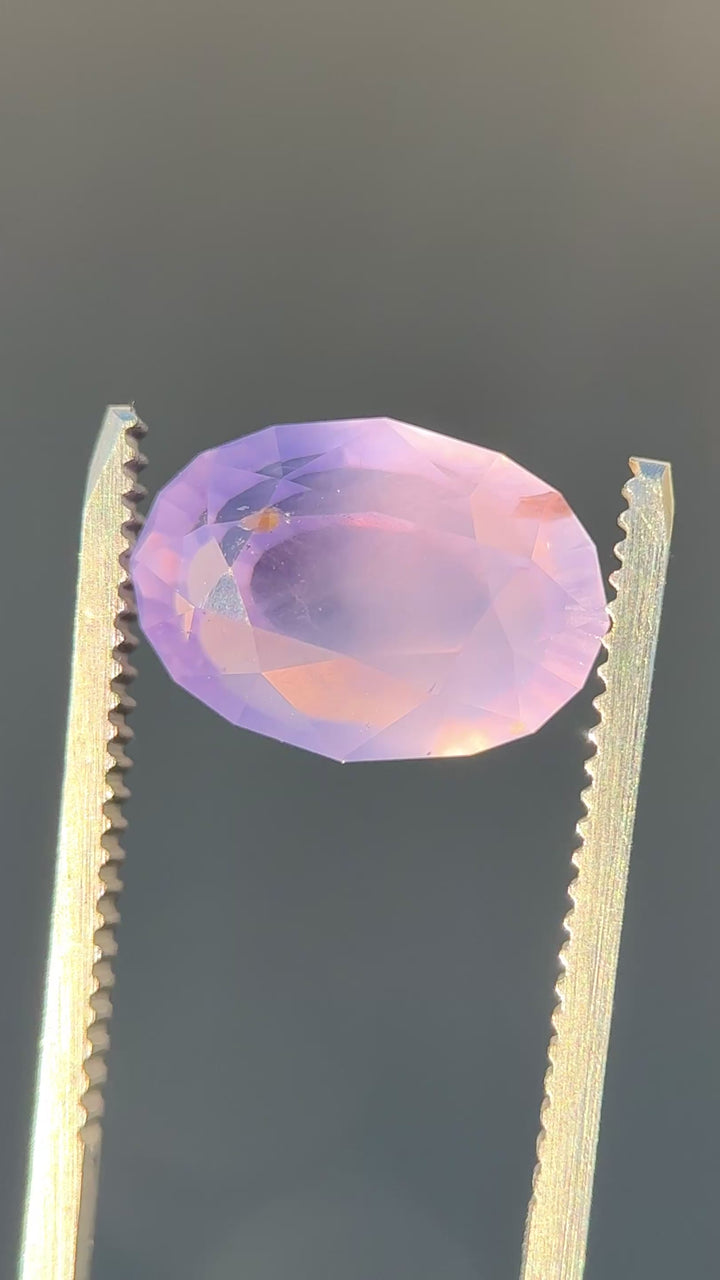 Large opalescent violet sapphire rotating in light showing soft glow and antique faceting.