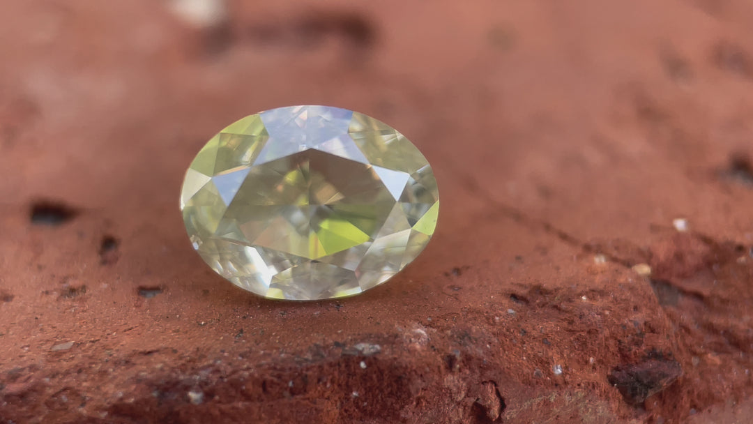 A close-up video of a 2.71-carat faint yellow opalescent oval modified brilliant diamond from South Africa, showcasing its light reflection and unique opalescent effect.