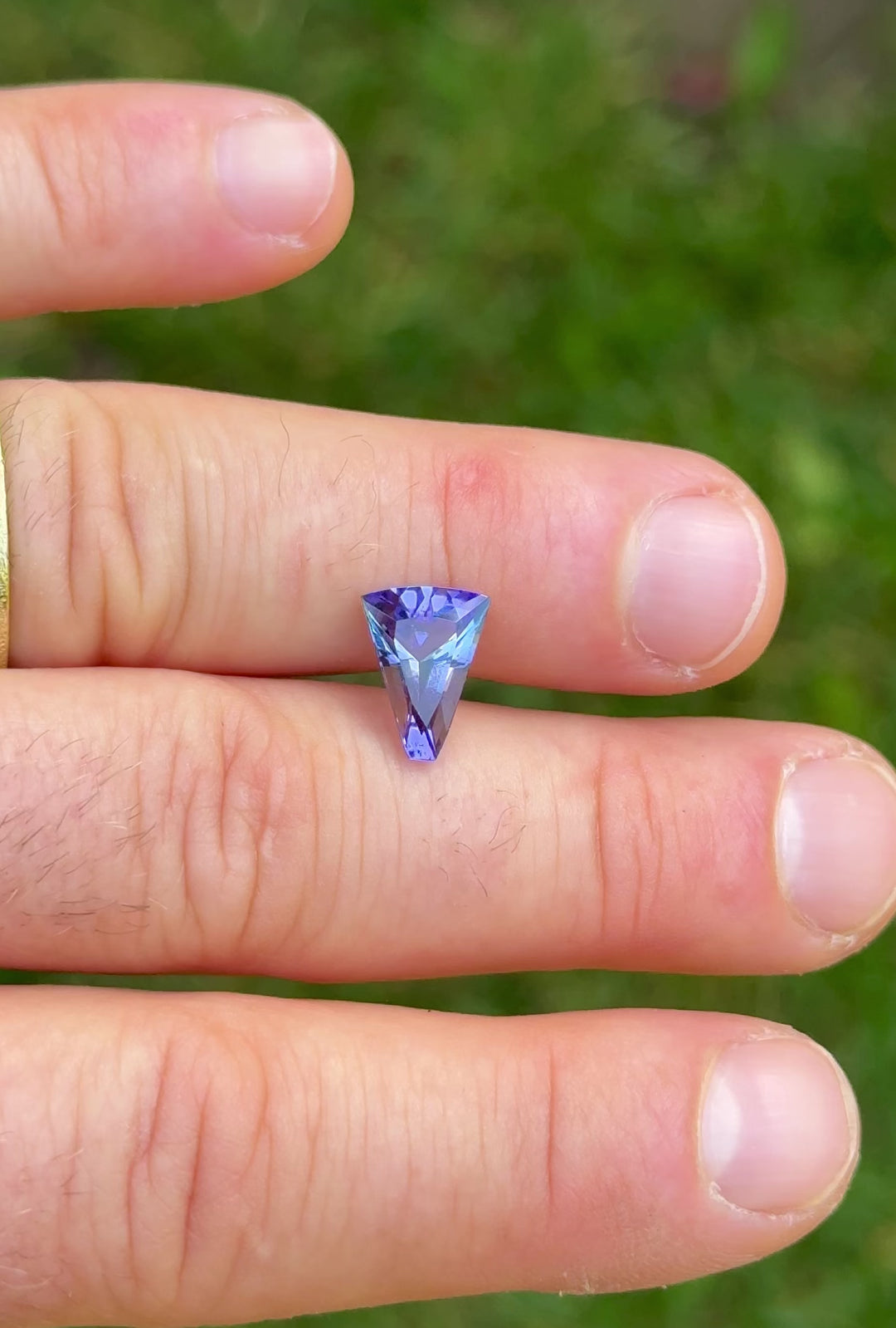 Handheld video of 2.74ct Tanzanite gemstone with custom fan cut, capturing sparkle and color shift between teal and purple