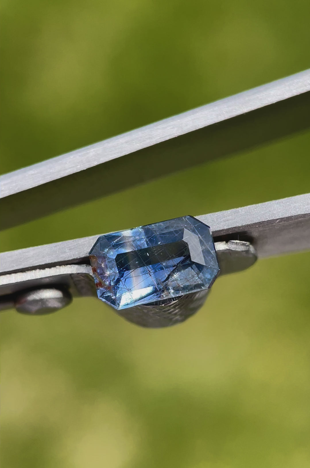 A video showcasing the brilliance and color shift of a 1.45-carat sapphire with teal and blue parti colors, highlighting its modified emerald cut.