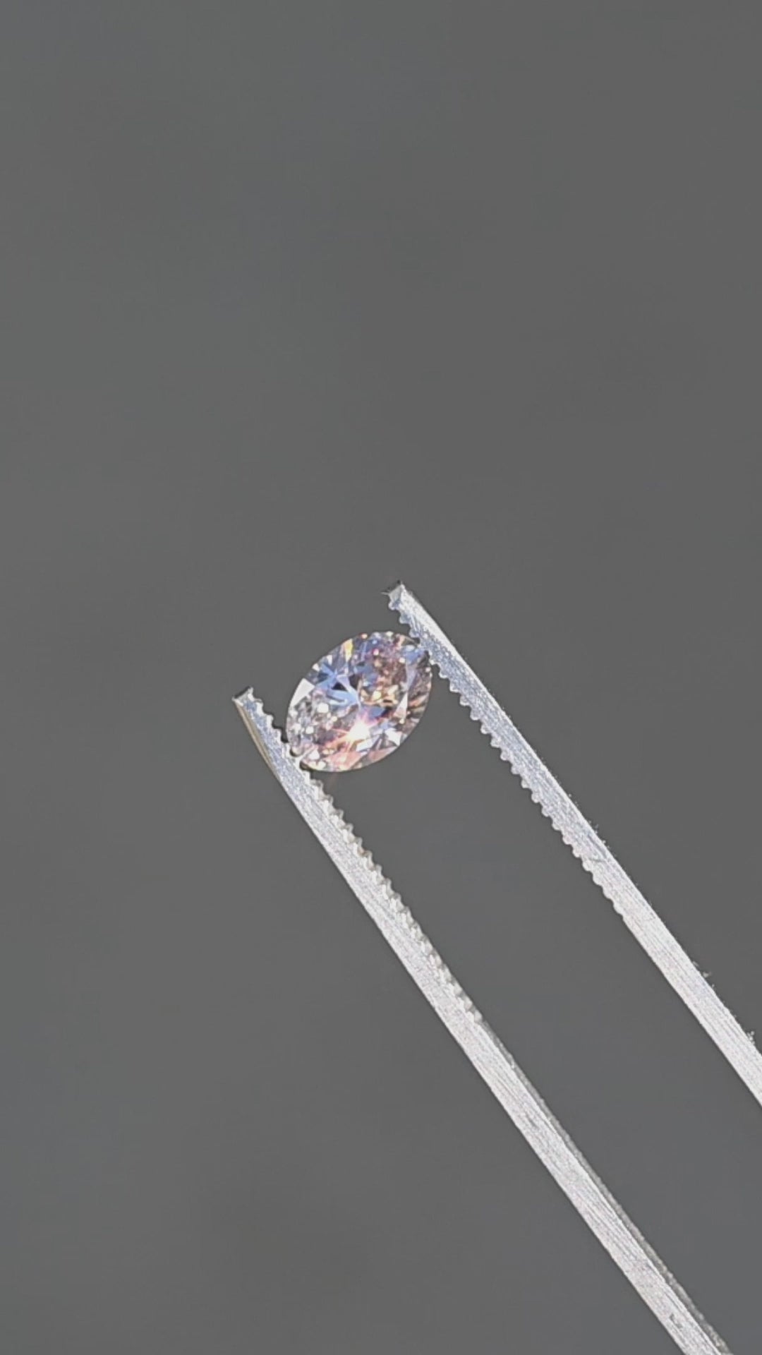 1.07ct natural champagne oval brilliant cut diamond from Canada rotating in gem tweezers under sunlight.